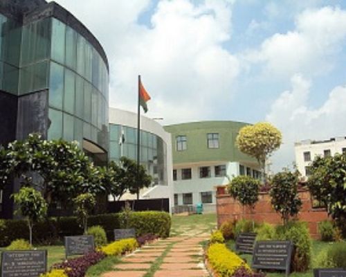"Main building facade of Indus Business Academy (IBA) Bangalore campus with lush green gardens."