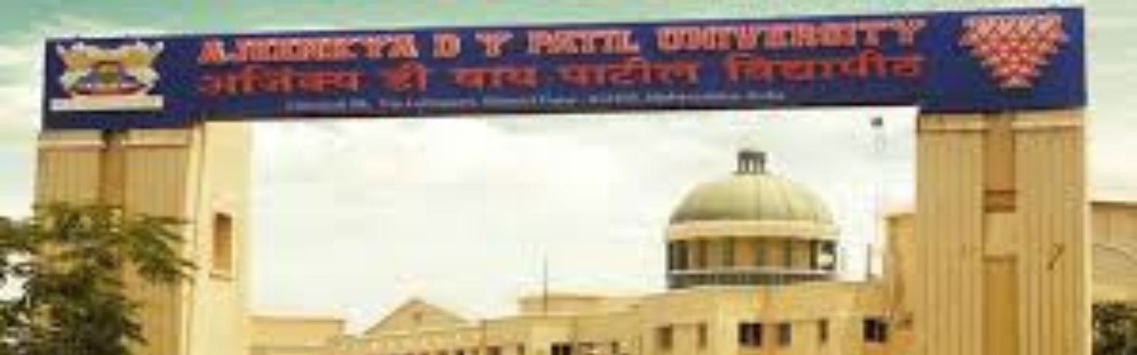 Alt Text: Aerial view of the Ajeenkya DY Patil University (ADYPU) Pune campus building, featuring classic white architecture with a central dome and lush green landscaping.